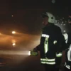 Firefighters using a handheld searchlight at night