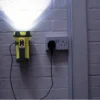Yellow searchlight illuminating a wall while connected to a charger